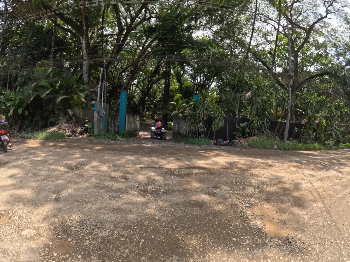 A gravel side road junction in Santa Teresa with potholes and loose surface