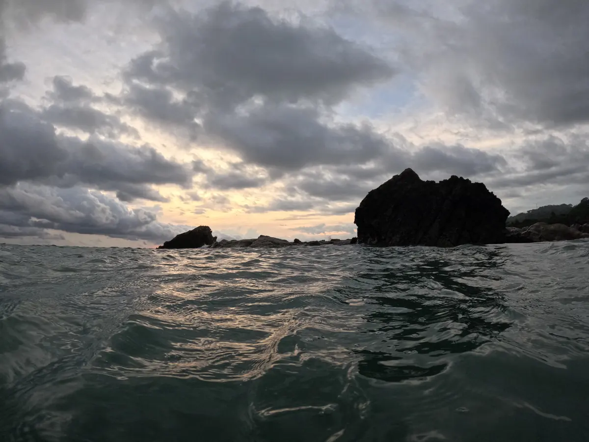 A rock outcrop seen from the water off the coast near Santa Teresa