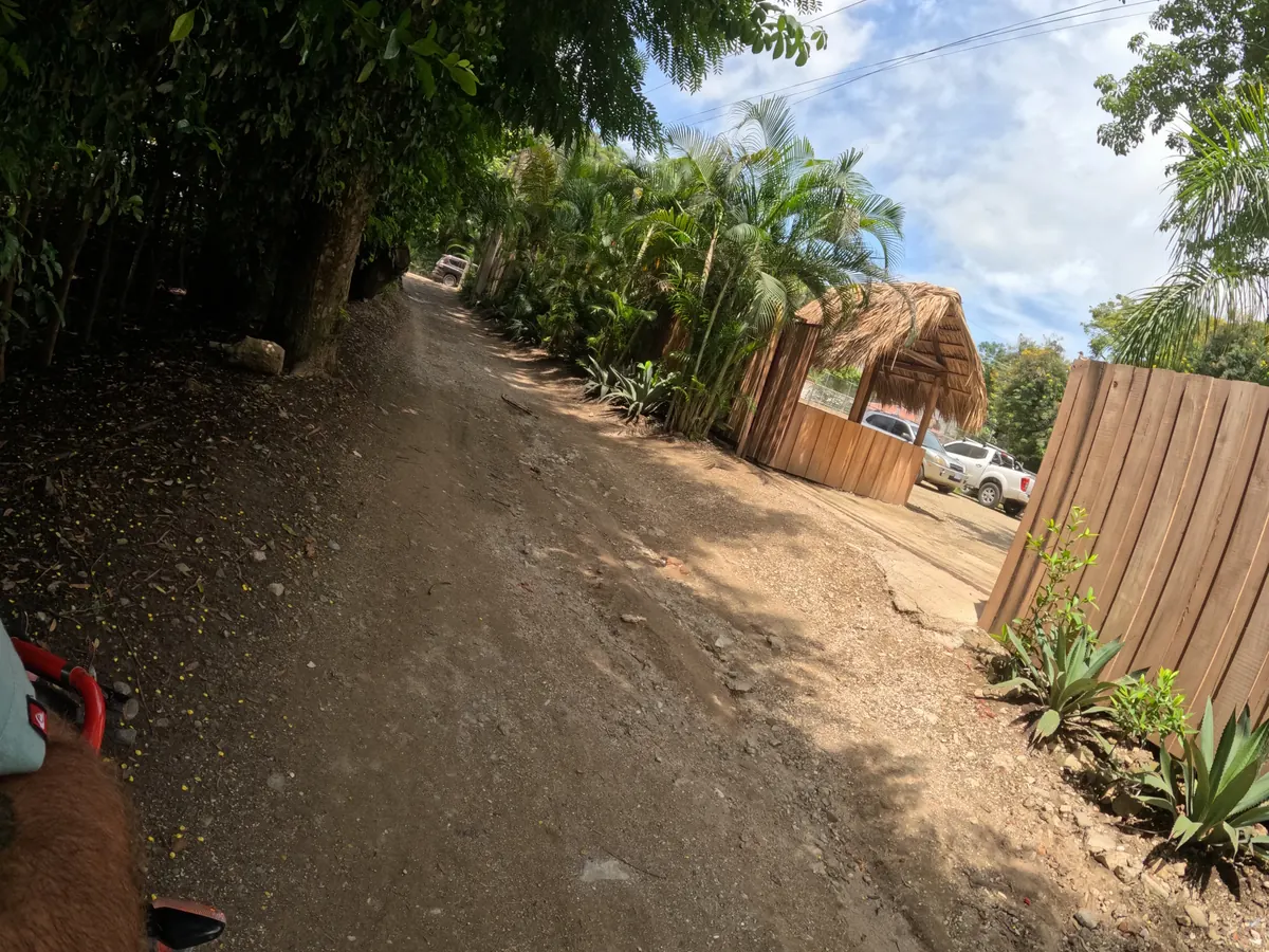 A dirt access road in Santa Teresa seen from the seat of an ATV, the kind of final stretch to check before you book